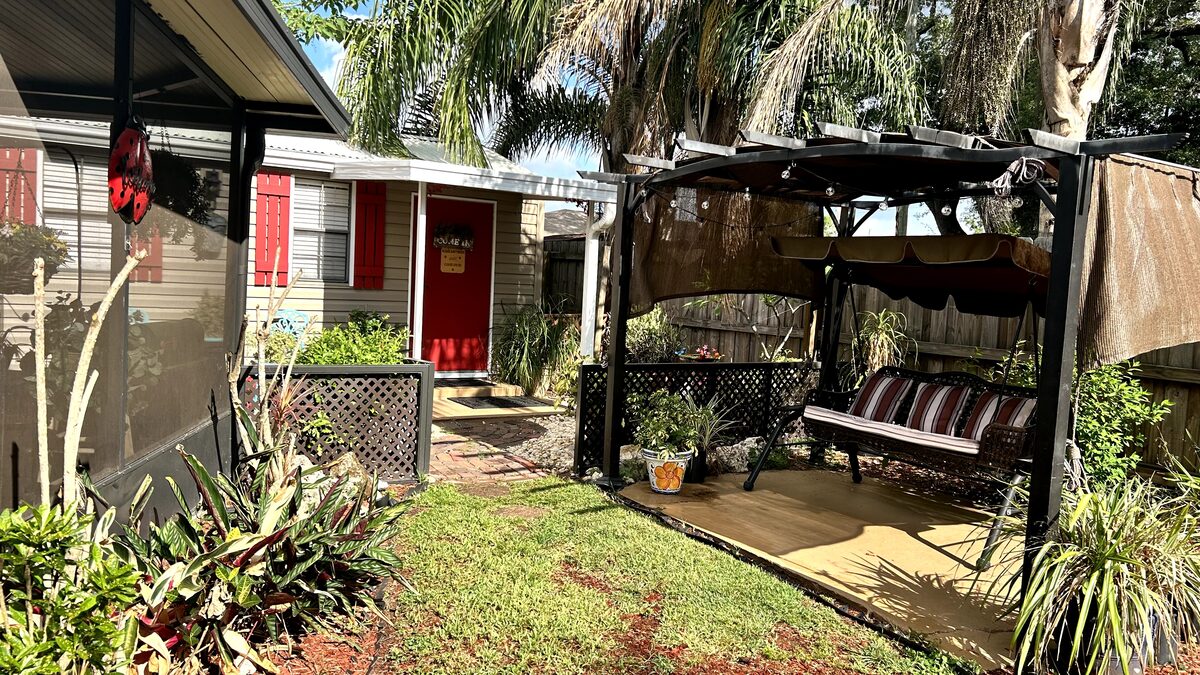 Pergola swing and lush garden alongside the grooming shed